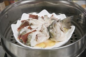 將鱸魚成花狀擺好，將火腿切片放入各縫隙中，放入鍋中隔水蒸12分鐘拿出，撒上蔥花即可。