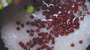 將炒好的食材和大米、紅豆一起放進(jìn)電飯鍋煮。