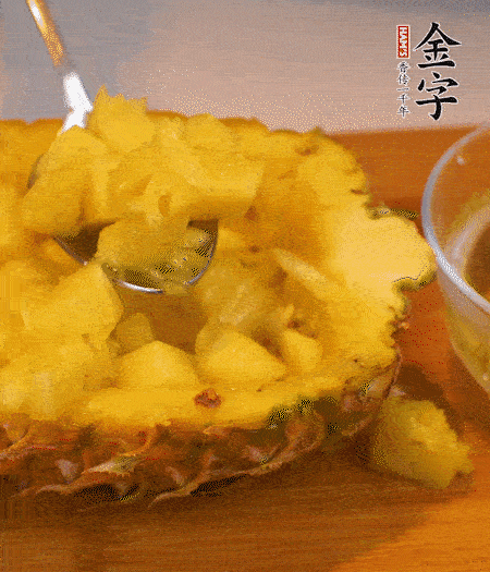 菠蘿對(duì)半切開(kāi)，切成小方格，用勺子把菠蘿肉挖出來(lái)。用鹽水稍浸泡。