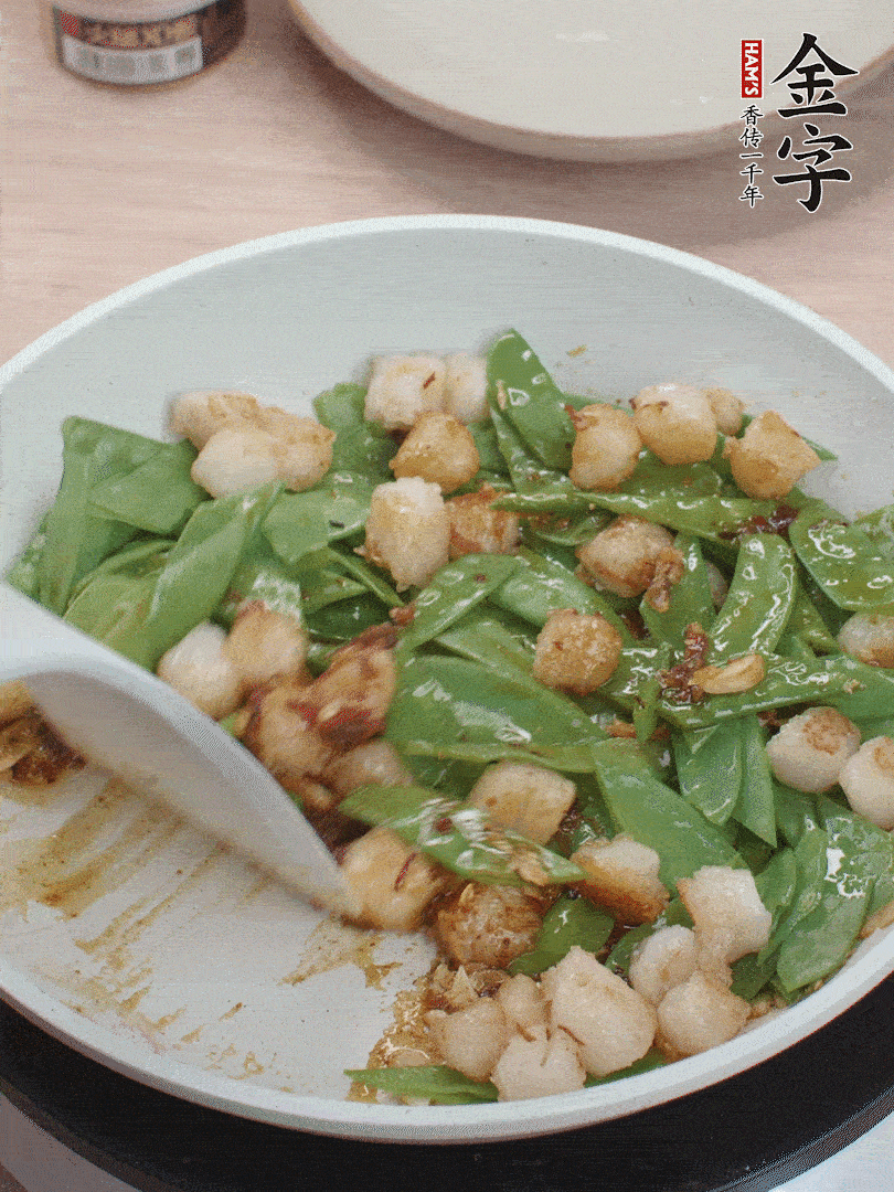 下甜豆莢、鮮貝輕輕翻炒均勻。