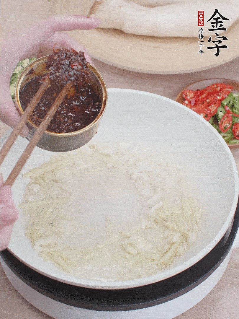 起鍋熱油，姜蒜、金字火腿干貝醬煸香。