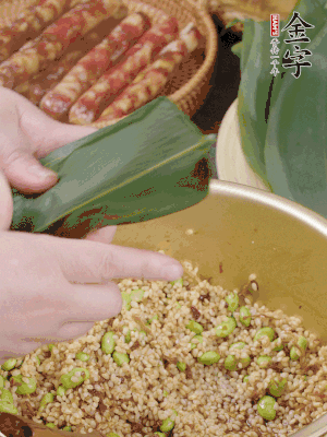 粽葉往下折，完全蓋住，兩側(cè)捏緊。