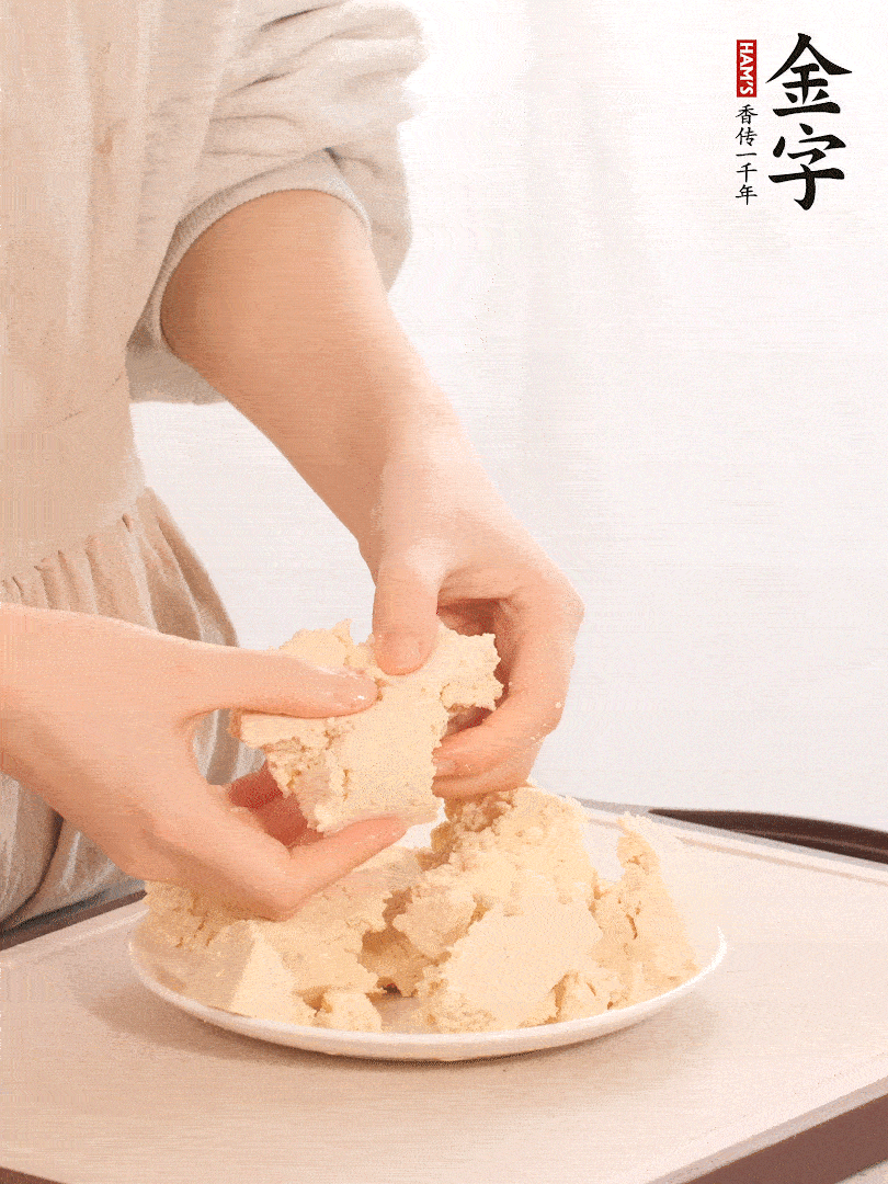 老豆腐用手掰成塊。