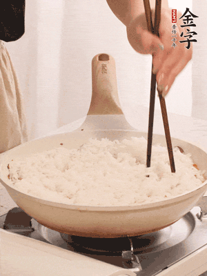 把瀝干水分的米飯均勻鋪在上面，筷子戳幾個洞，以便透氣，轉(zhuǎn)小火蓋上蓋子燜至水分收干，大概10分鐘。